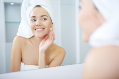 stock-photo-84255193-beautiful-young-woman-applying-facial-moisturizing-cream-skincare-concept